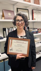 professor with award certificate